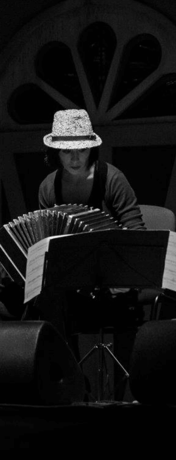 mujer tocando bandoneon en un escenario