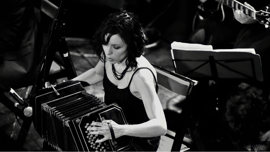 mujer tocando bandoneon en un escenario blanco y negro 