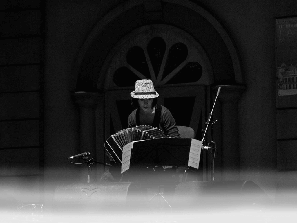 mujer tocando bandoneón en un escenario